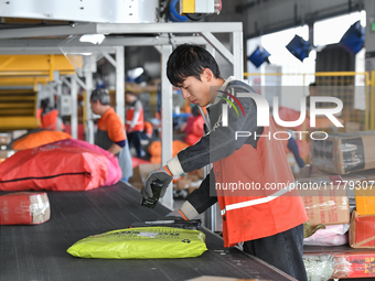 Workers work at the newly operational STO Express Hefei transit center in Hefei, China, on November 13, 2024. (