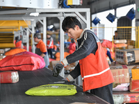 Workers work at the newly operational STO Express Hefei transit center in Hefei, China, on November 13, 2024. (