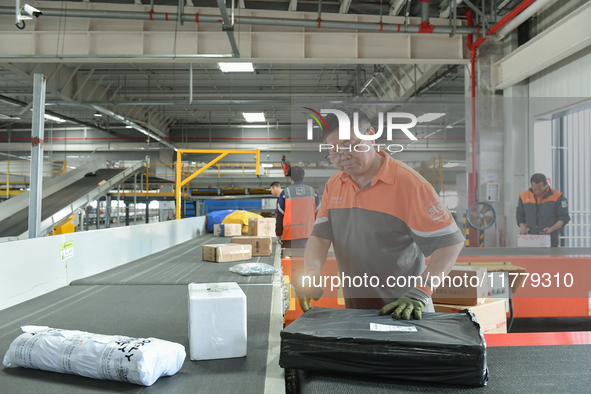 Workers work at the newly operational STO Express Hefei transit center in Hefei, China, on November 13, 2024. 