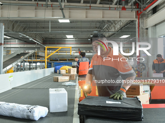 Workers work at the newly operational STO Express Hefei transit center in Hefei, China, on November 13, 2024. (