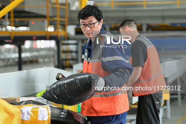 Workers work at the newly operational STO Express Hefei transit center in Hefei, China, on November 13, 2024. 