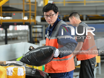 Workers work at the newly operational STO Express Hefei transit center in Hefei, China, on November 13, 2024. (