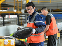 Workers work at the newly operational STO Express Hefei transit center in Hefei, China, on November 13, 2024. (