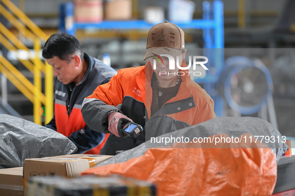 Workers work at the newly operational STO Express Hefei transit center in Hefei, China, on November 13, 2024. 