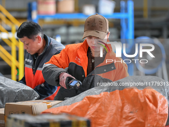 Workers work at the newly operational STO Express Hefei transit center in Hefei, China, on November 13, 2024. (