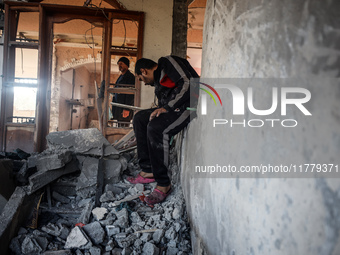 Palestinians inspect the site of an Israeli strike on a house in Deir Al-Balah in the central Gaza Strip on November 15, 2024. (