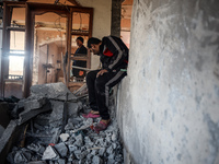 Palestinians inspect the site of an Israeli strike on a house in Deir Al-Balah in the central Gaza Strip on November 15, 2024. (