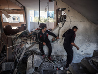 Palestinians inspect the site of an Israeli strike on a house in Deir Al-Balah in the central Gaza Strip on November 15, 2024. (