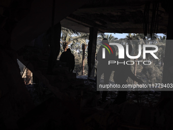 Palestinians inspect the site of an Israeli strike on a house in Deir Al-Balah in the central Gaza Strip on November 15, 2024. (