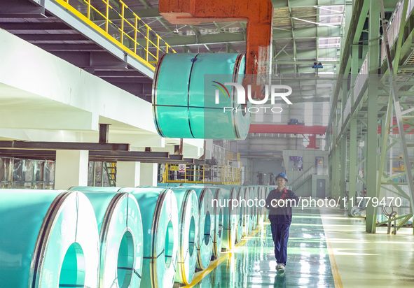 A worker produces precision stainless steel strip at the intelligent control center of Beitai Nantong Metal Technology Co., LTD in Haian, Ji...