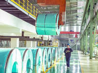 A worker produces precision stainless steel strip at the intelligent control center of Beitai Nantong Metal Technology Co., LTD in Haian, Ji...