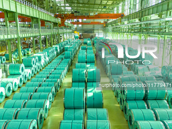 A worker produces precision stainless steel strip at the intelligent control center of Beitai Nantong Metal Technology Co., LTD in Haian, Ji...