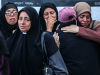 Relatives mourn during the funeral of Palestinians killed in an Israeli strike on tents of displaced people in Deir Al-Balah, Gaza Strip, on...