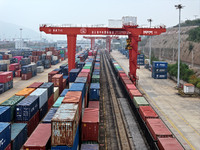 Large machinery loads containers onto the China-Kazakhstan (Lianyungang) Logistics Cooperation Base for the China-Europe freight train in Li...