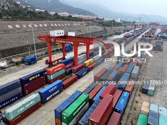 Large machinery loads containers onto the China-Kazakhstan (Lianyungang) Logistics Cooperation Base for the China-Europe freight train in Li...