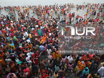 Hindu people gather to float small decorated boats made with banana stems as they take a holy dip in the river Ganges on the occasion of a h...