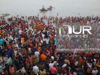 Hindu people gather to float small decorated boats made with banana stems as they take a holy dip in the river Ganges on the occasion of a h...