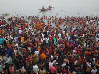 Hindu people gather to float small decorated boats made with banana stems as they take a holy dip in the river Ganges on the occasion of a h...