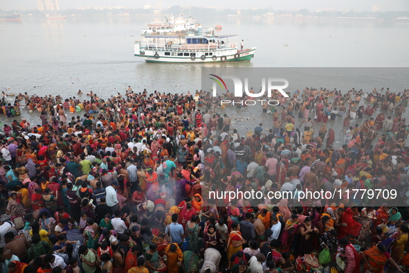 Hindu people gather to float small decorated boats made with banana stems as they take a holy dip in the river Ganges on the occasion of a h...