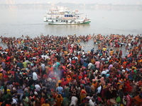 Hindu people gather to float small decorated boats made with banana stems as they take a holy dip in the river Ganges on the occasion of a h...