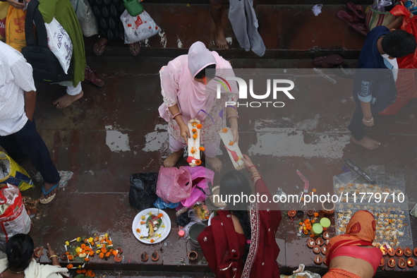 Hindu people offer prayers and float small decorated boats made with banana stems as people gather to take a holy dip in the river Ganges on...