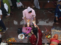 Hindu people offer prayers and float small decorated boats made with banana stems as people gather to take a holy dip in the river Ganges on...