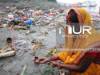 Hindu people offer prayers and float small decorated boats made with banana stems as people gather to take a holy dip in the river Ganges on...