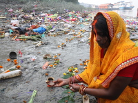 Hindu people offer prayers and float small decorated boats made with banana stems as people gather to take a holy dip in the river Ganges on...