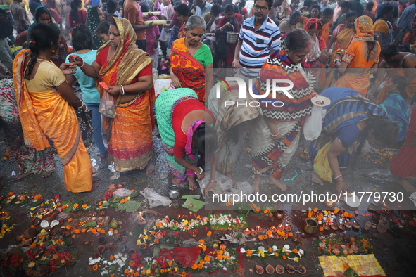 Hindu people offer prayers and float small decorated boats made with banana stems as people gather to take a holy dip in the river Ganges on...