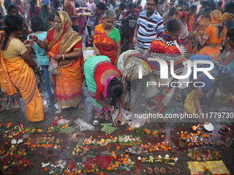 Hindu people offer prayers and float small decorated boats made with banana stems as people gather to take a holy dip in the river Ganges on...