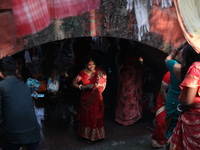 Hindu people participate in floating decorated boats made with banana stems as people gather to take a holy dip in the river Ganges on the o...