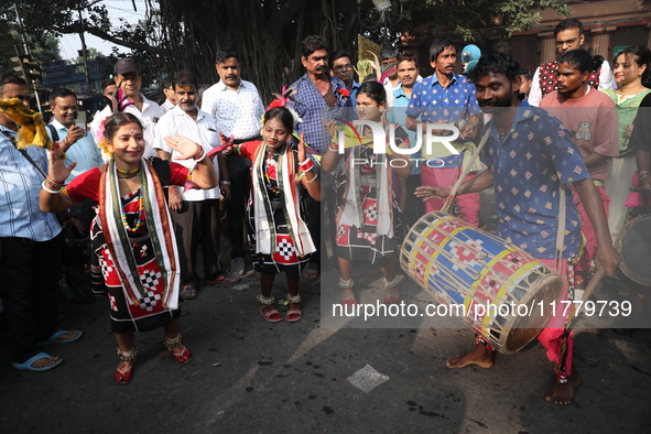 Hindu people dance before they float a decorated boat made with a banana stem as people gather to take a holy dip in the river Ganges on the...