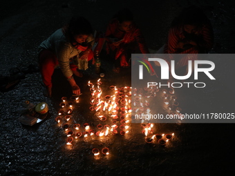 Hindu devotees light oil lamps on the banks of the river Ganges on the occasion of the Hindu religious festival of Dev Deepawali in Kolkata,...