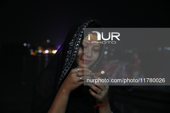 Hindu devotees light oil lamps on the banks of the river Ganges on the occasion of the Hindu religious festival of Dev Deepawali in Kolkata,...