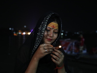 Hindu devotees light oil lamps on the banks of the river Ganges on the occasion of the Hindu religious festival of Dev Deepawali in Kolkata,...