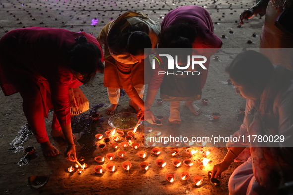 Hindu devotees light oil lamps on the banks of the river Ganges on the occasion of the Hindu religious festival of Dev Deepawali in Kolkata,...