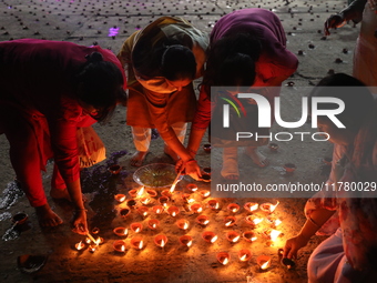 Hindu devotees light oil lamps on the banks of the river Ganges on the occasion of the Hindu religious festival of Dev Deepawali in Kolkata,...