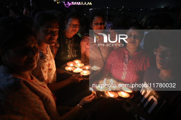 Hindu devotees light oil lamps on the banks of the river Ganges on the occasion of the Hindu religious festival of Dev Deepawali in Kolkata,...