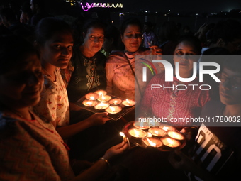 Hindu devotees light oil lamps on the banks of the river Ganges on the occasion of the Hindu religious festival of Dev Deepawali in Kolkata,...