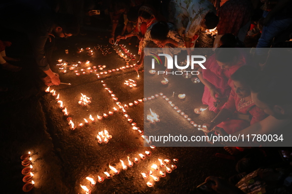 Hindu devotees light oil lamps on the banks of the river Ganges on the occasion of the Hindu religious festival of Dev Deepawali in Kolkata,...