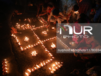 Hindu devotees light oil lamps on the banks of the river Ganges on the occasion of the Hindu religious festival of Dev Deepawali in Kolkata,...