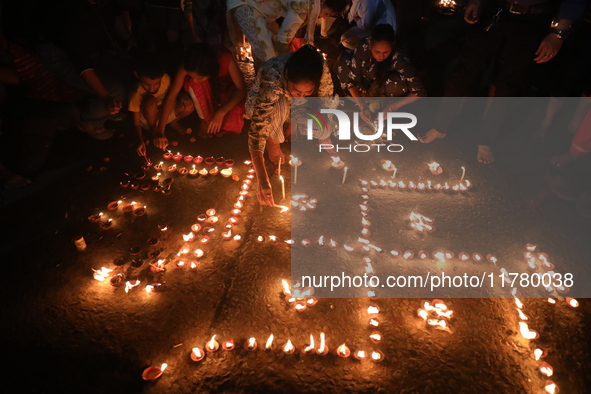 Hindu devotees light oil lamps on the banks of the river Ganges on the occasion of the Hindu religious festival of Dev Deepawali in Kolkata,...