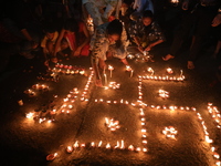 Hindu devotees light oil lamps on the banks of the river Ganges on the occasion of the Hindu religious festival of Dev Deepawali in Kolkata,...