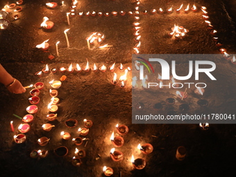 Hindu devotees light oil lamps on the banks of the river Ganges on the occasion of the Hindu religious festival of Dev Deepawali in Kolkata,...