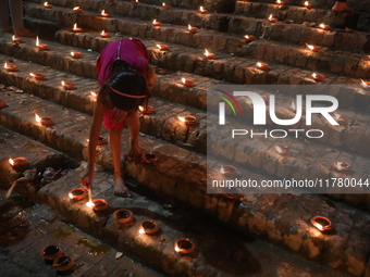 Hindu devotees light oil lamps on the banks of the river Ganges on the occasion of the Hindu religious festival of Dev Deepawali in Kolkata,...