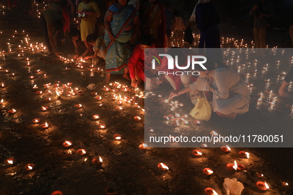 Hindu devotees light oil lamps on the banks of the river Ganges on the occasion of the Hindu religious festival of Dev Deepawali in Kolkata,...