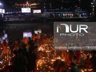 Hindu devotees light oil lamps on the banks of the river Ganges on the occasion of the Hindu religious festival of Dev Deepawali in Kolkata,...