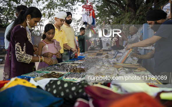 Sikh people buy religious items at a stall near a Gurudwara on the occasion of Guru Nanak Jayanti in Guwahati, Assam, India, on November 15,...