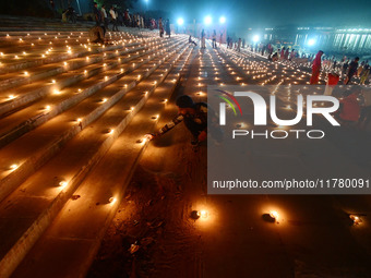 Devotees light traditional oil lamps as they celebrate the Hindu festival of 'Dev Deepawali' at Sangam, the confluence of the rivers Ganges,...