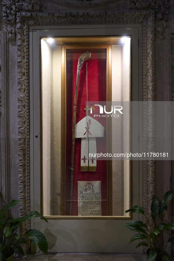 This image shows the wooden pastoral symbols of Italian Bishop Tonino Bello, including his mitre, pastoral staff, wooden cross, and ring. Bi...